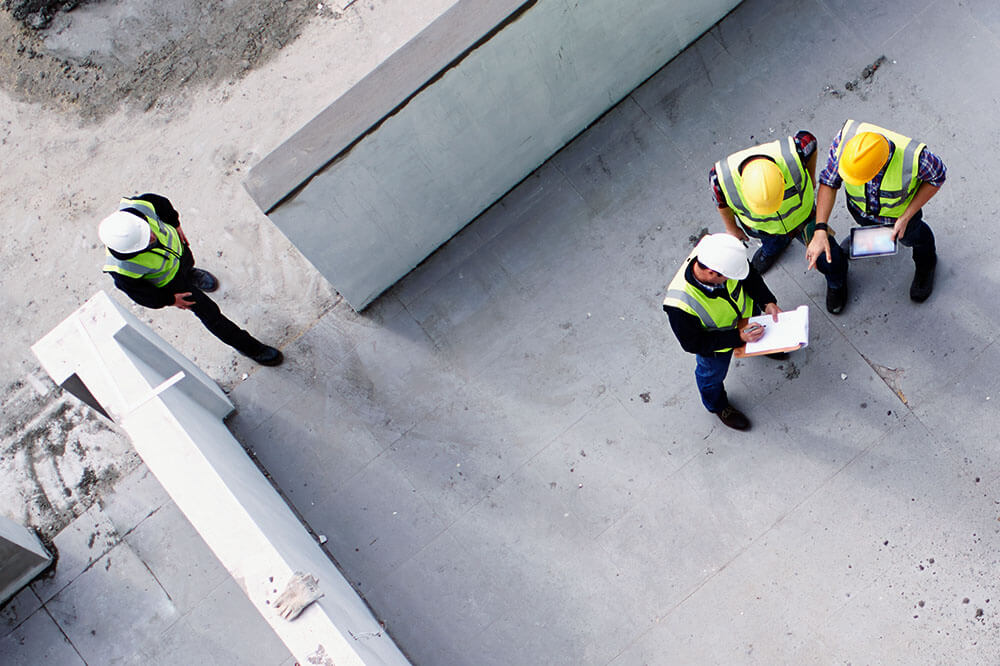 drone shot of construction workers looking over plans